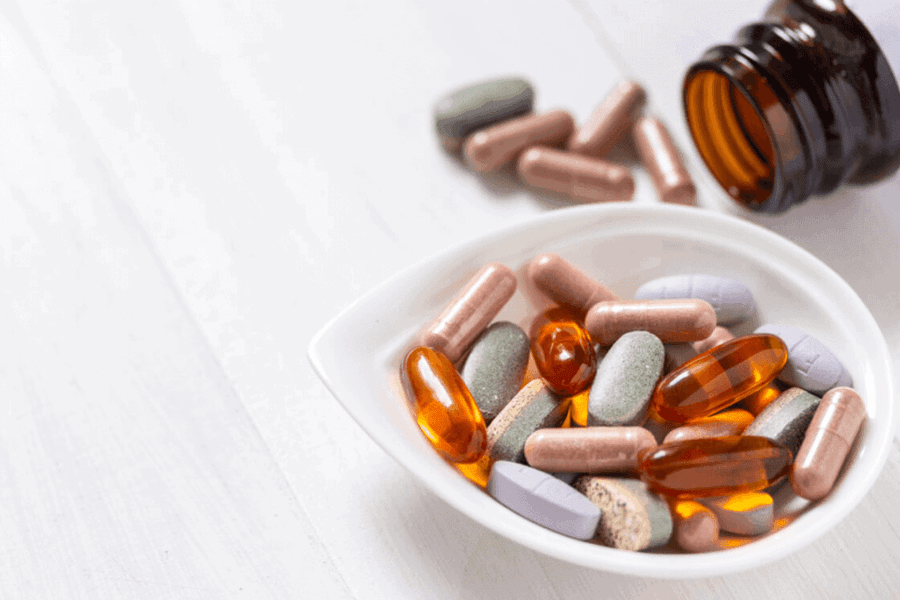 supplements in a white container next to supplement bottle