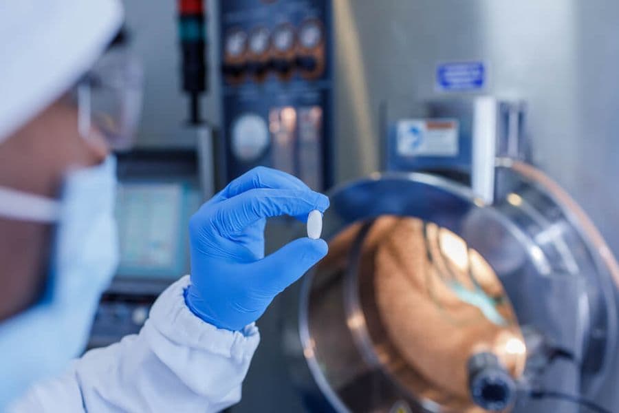 person holding a supplement in a lab