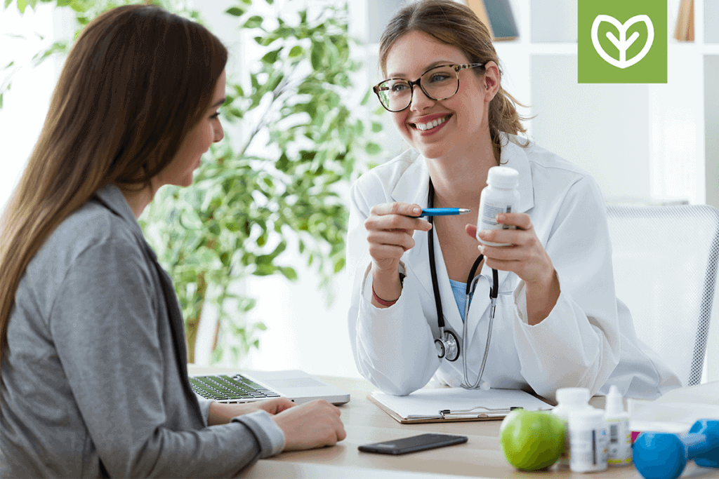 practitioner pointing to supplement bottle while talking to a patient