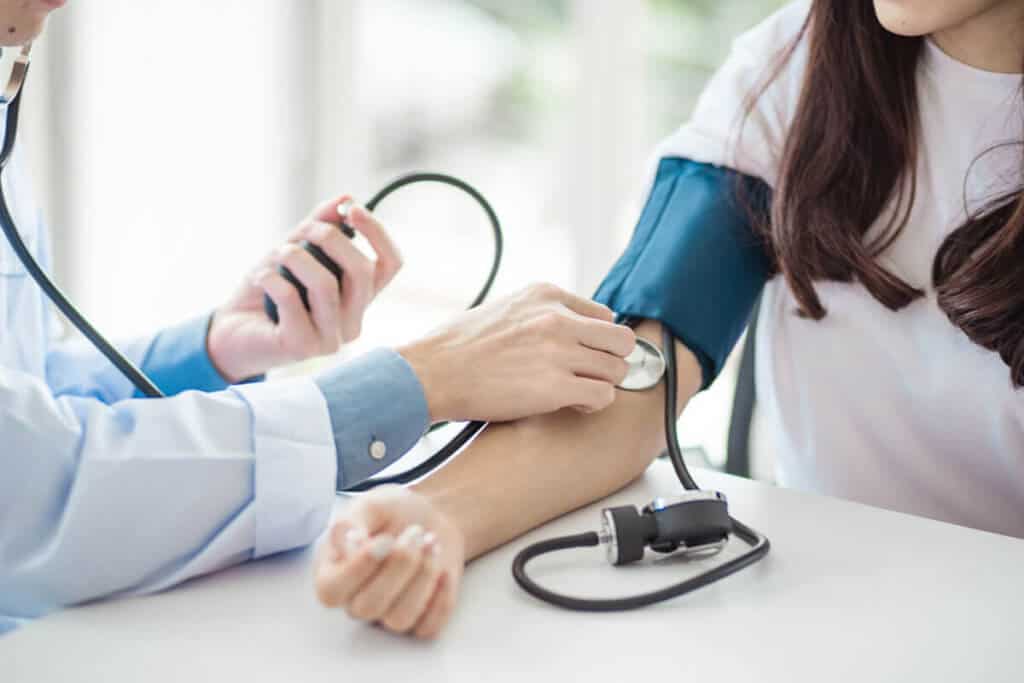 doctor taking the blood pressure of a patient