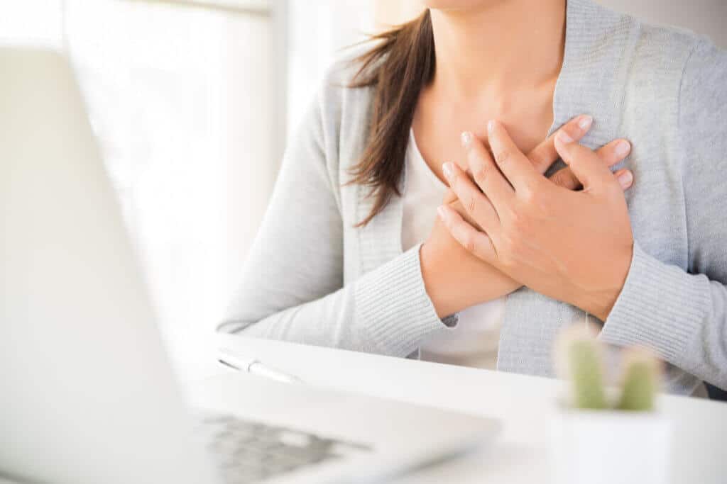 close up of woman holding her chest