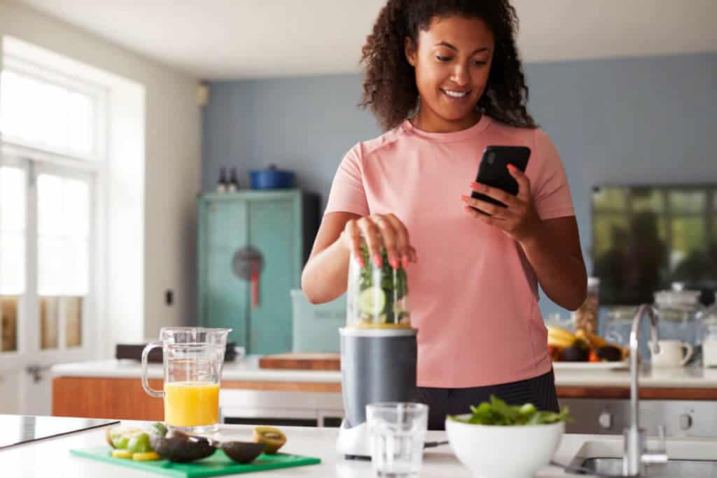 woman making a smoothie with vegetables
