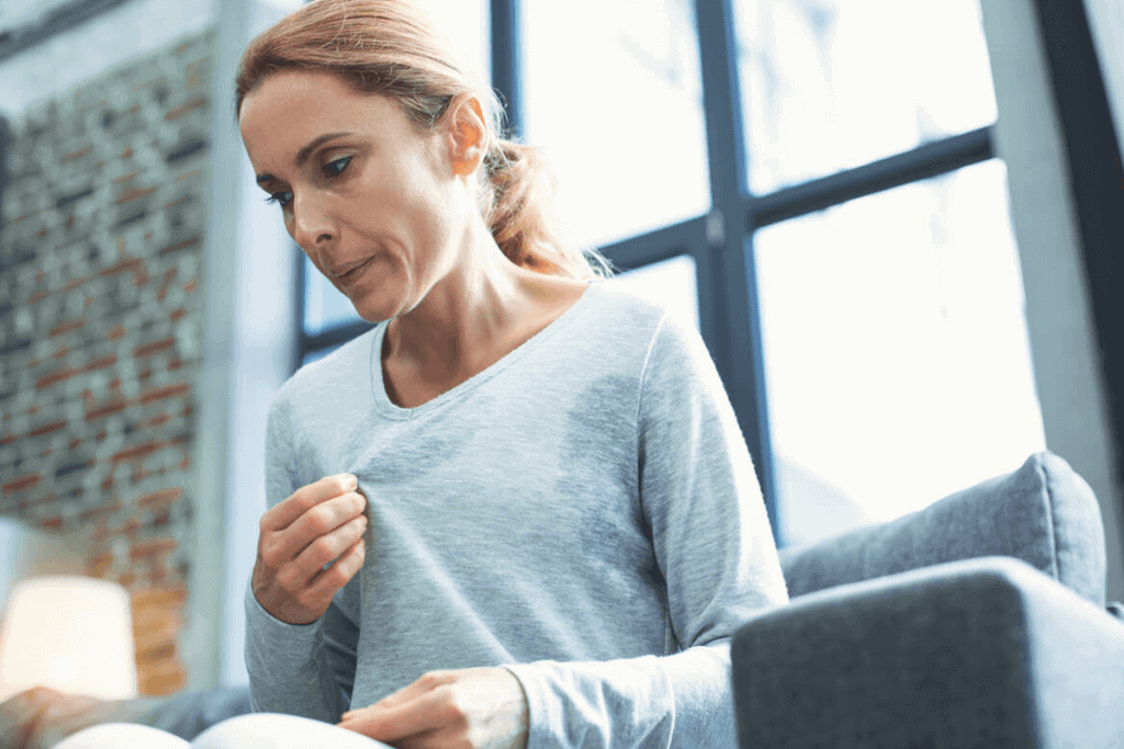 woman blowing air in her shirt to cool down