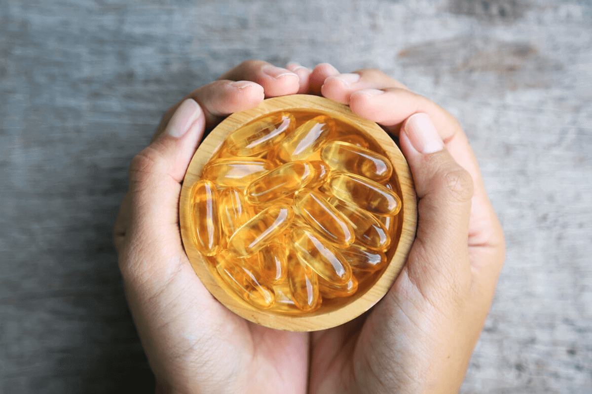 person holding a bowl of fish oil