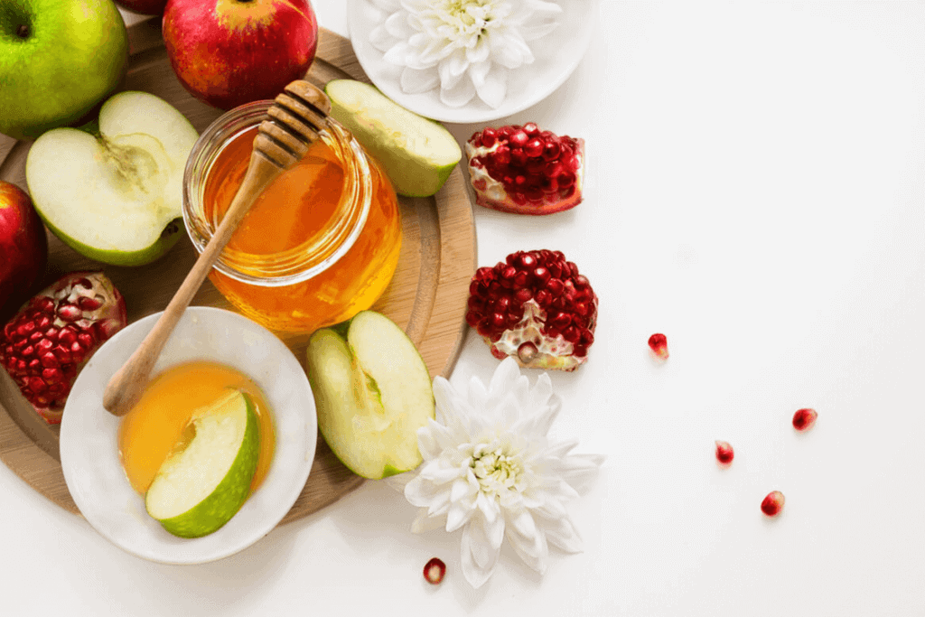apples, honey and pomegranate on a table
