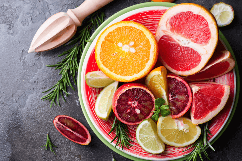 Colorful sliced citrus on a plate over a slate backdrop