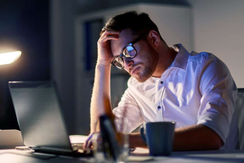 man looking at his laptop at night