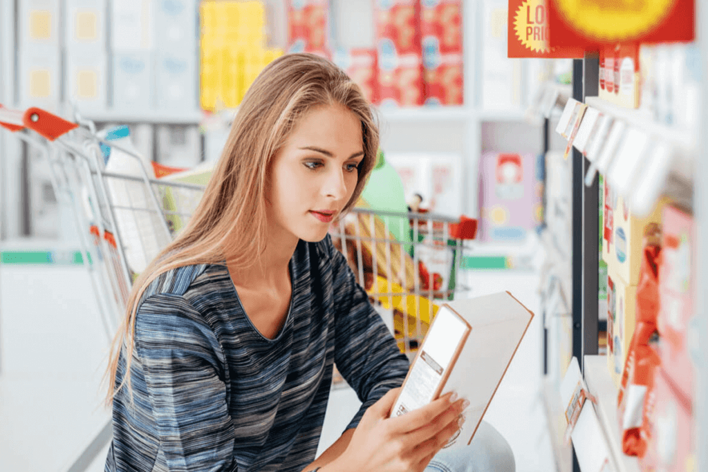 woman in grocery store looking at the label of a packaged item