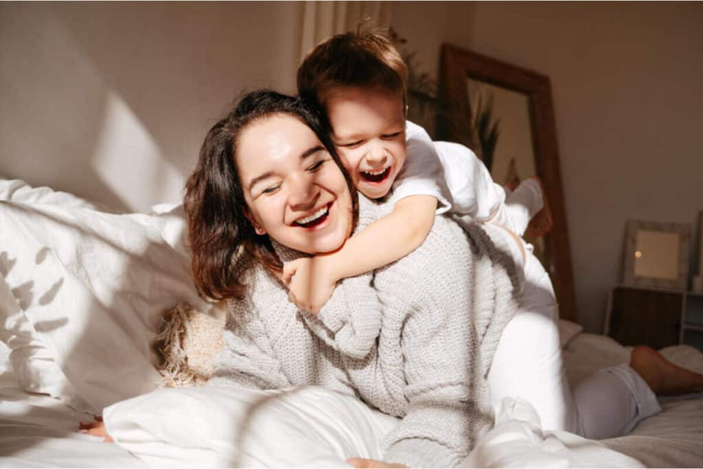 child hugging their mom's while piggy backing