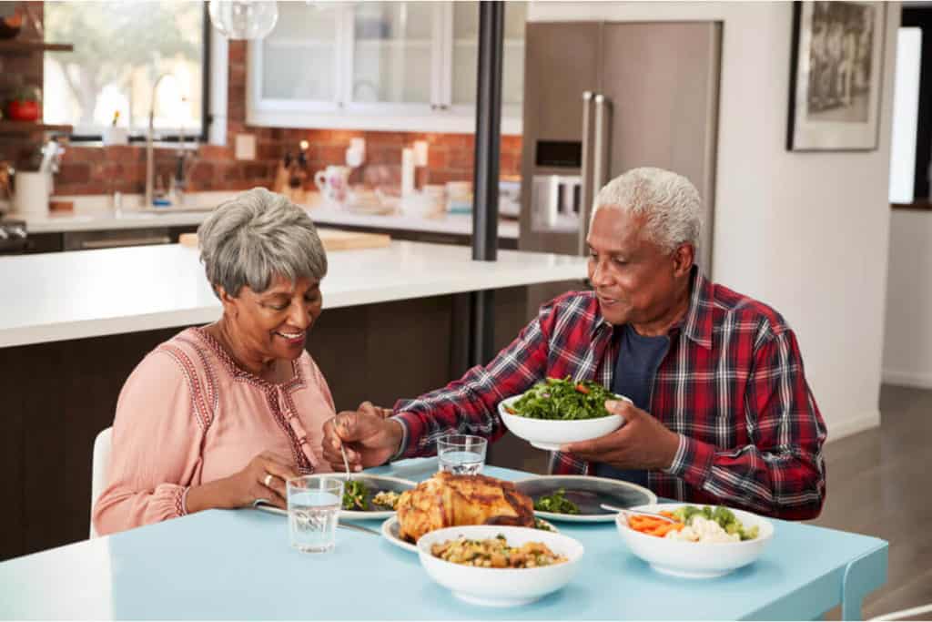 man and woman sitting at a dining table eating
