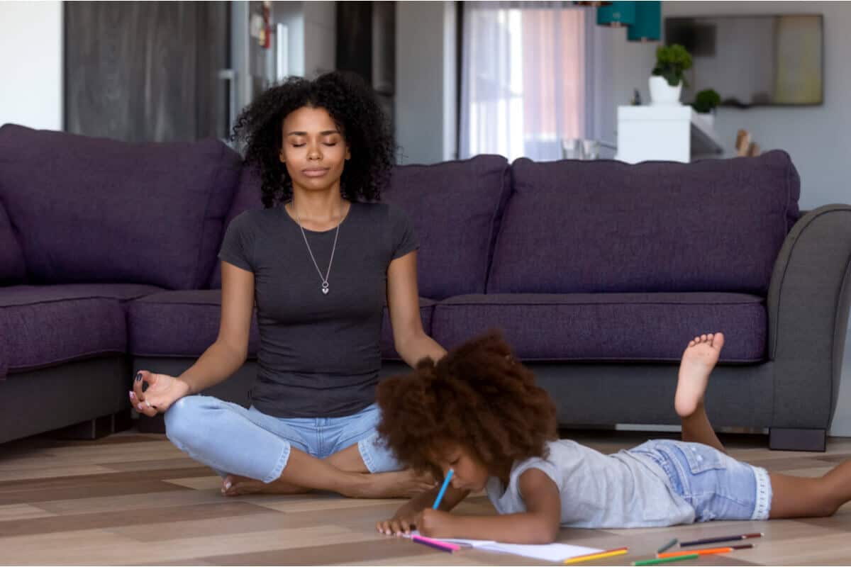 mother meditating with daughter next to her drawing