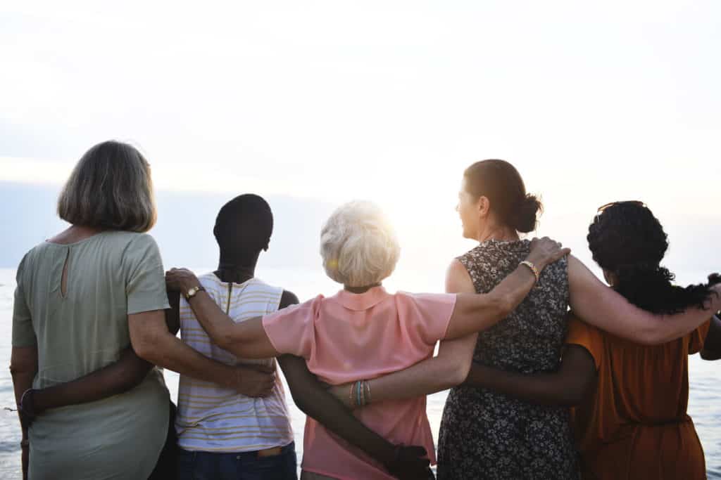 Five women with their arms around each other