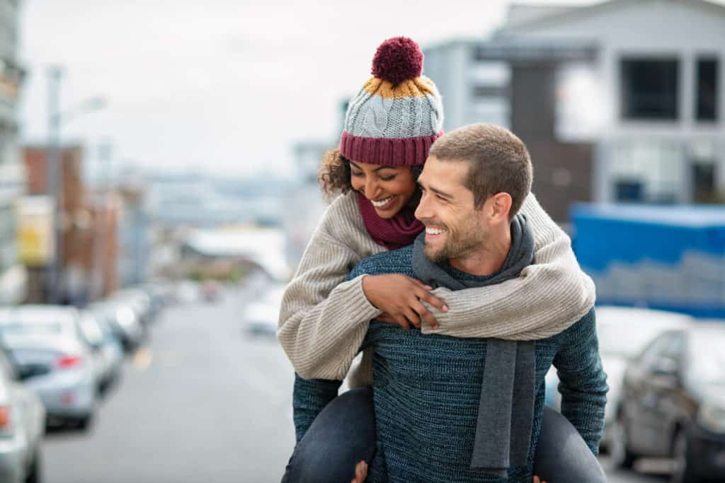 Woman hugging man form behind
