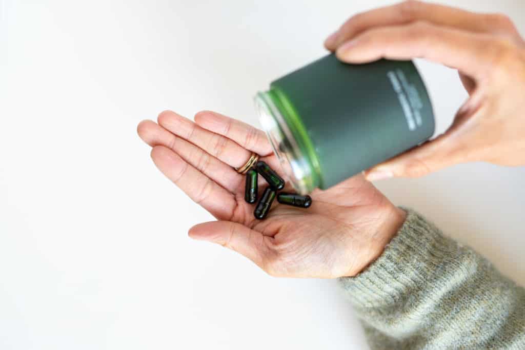 Person holding a bottle of vitamins