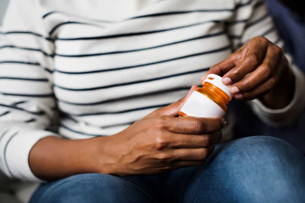 Woman holding supplement bottle
