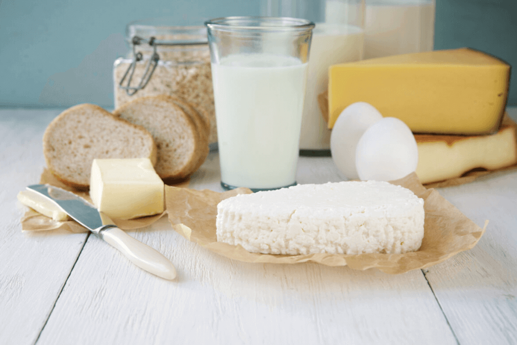 Dairy products, bread, and eggs on a white tabletop.