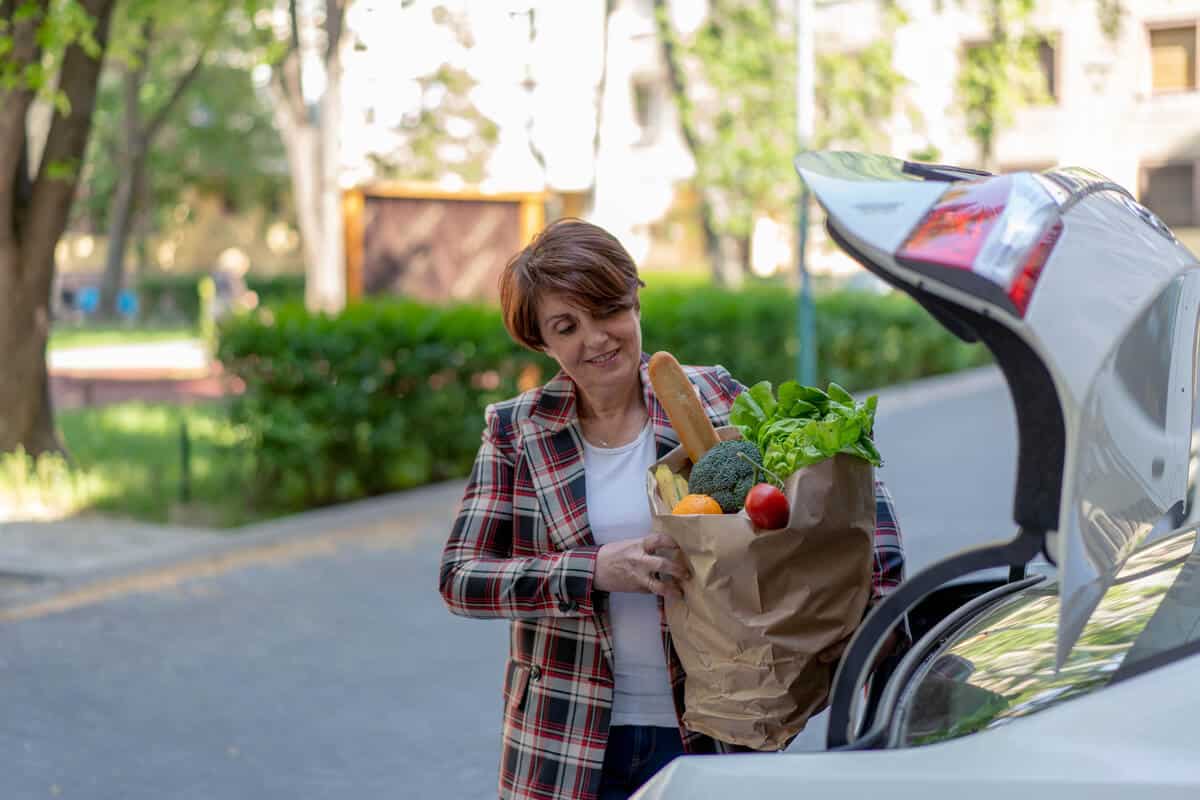 Woman loading groceries into her car 