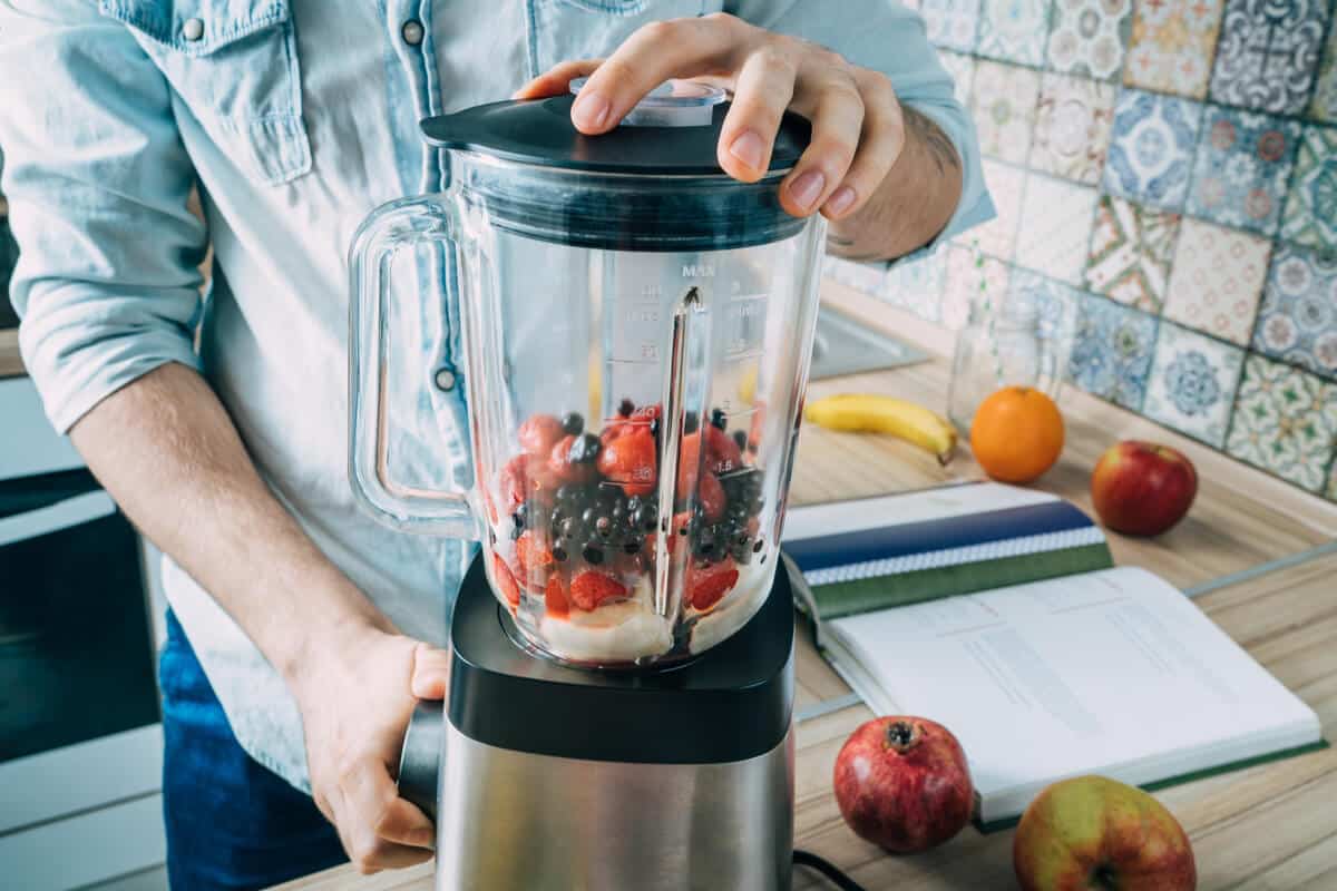 Man making a smoothie in a blender 