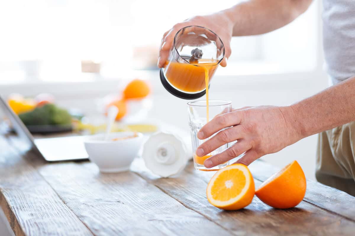 Man pouring a glass of orange juice
