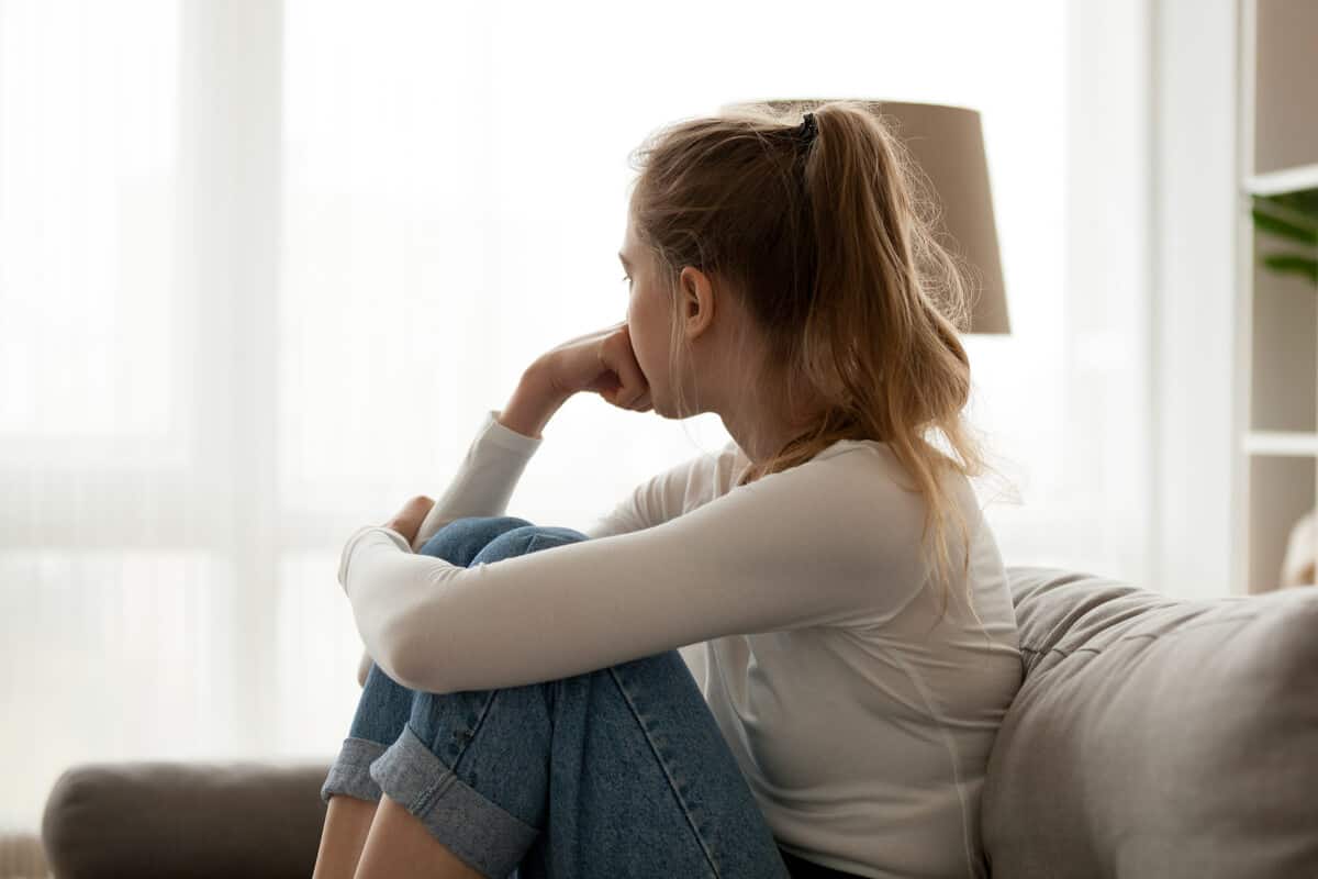 woman sitting on a couch looking out a window
