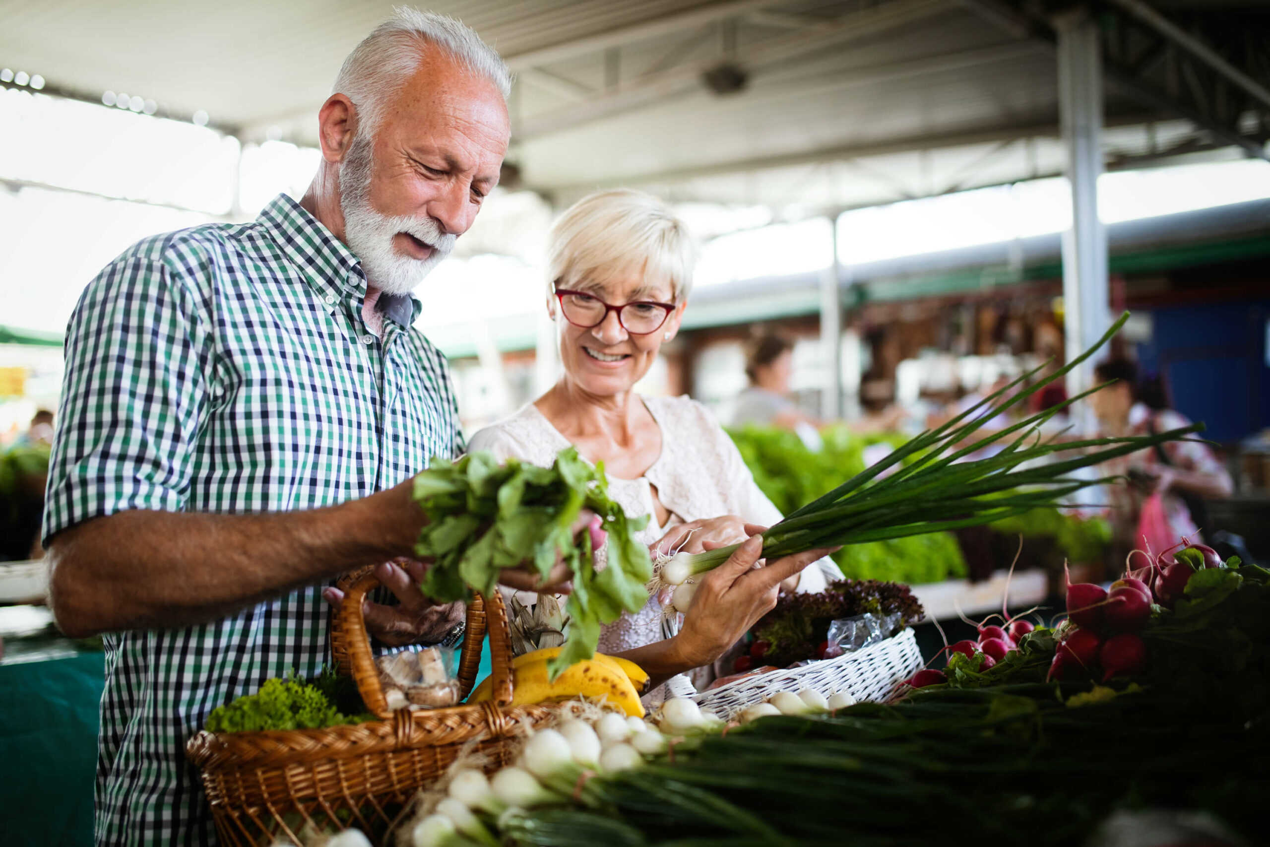 two elderly people looking at produce