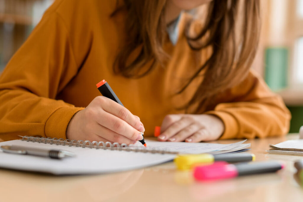 person highlighting text in a notebook
