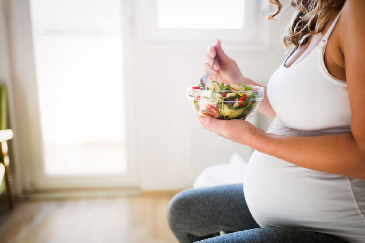 pregnant woman eating a salad