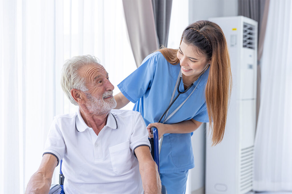 A nurse is helping a man in a wheelchair, providing assistance indoors.