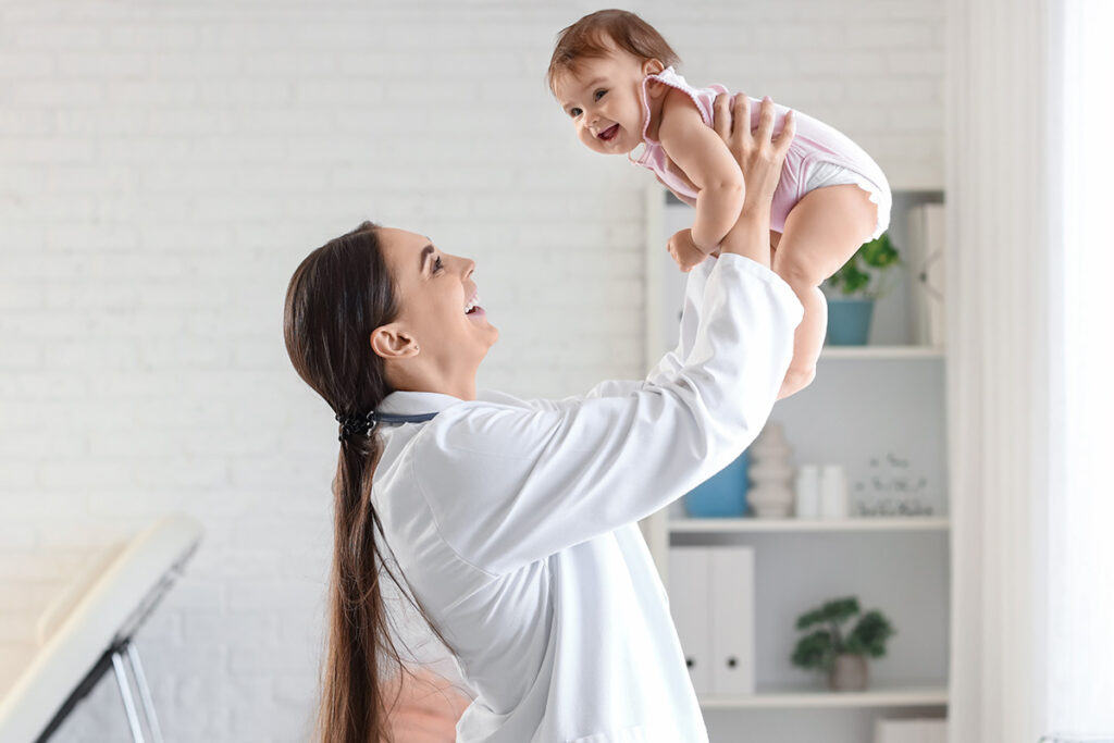 A woman is holding a baby close to her.